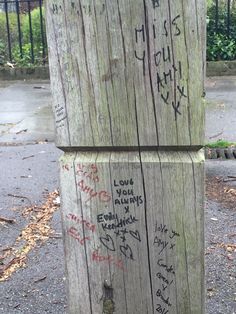 a wooden post with graffiti written on it