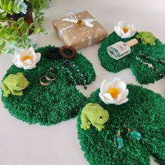 some green grass with flowers and rings on it next to a brown gift box,