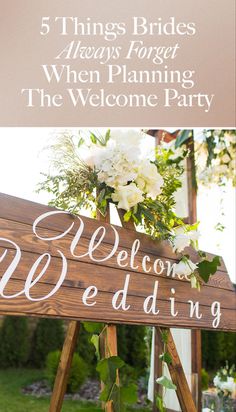 a wooden welcome sign with flowers and greenery on it for an outdoor wedding ceremony