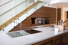 a kitchen with an oven, counter and stairs