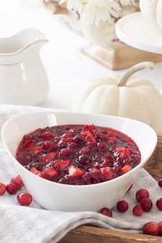 a white bowl filled with cranberry sauce on top of a table