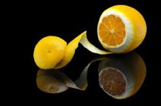 two oranges cut in half on a reflective surface