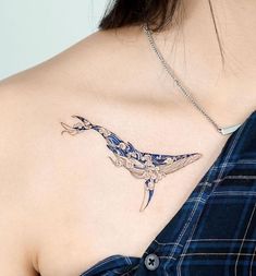 a woman with a tattoo on her chest is wearing a blue dress and has a whale