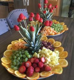 two plates filled with fruit on top of a wooden table