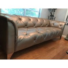 a leather couch sitting on top of a hard wood floor