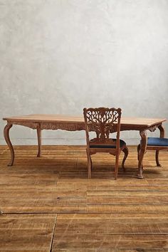 a wooden table and two chairs sitting on top of a hard wood floor