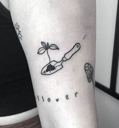 a woman's arm with a small tattoo on it that says flower and a knife