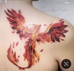 the back of a woman's shoulder with red and yellow feathers painted on it