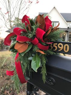 a christmas wreath on the mailbox in front of a house