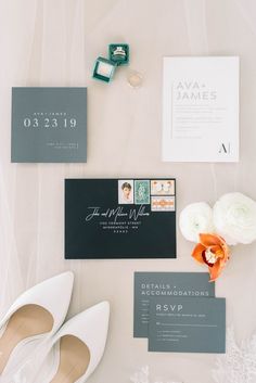 the wedding stationery is laid out on top of the bride's dress and shoes