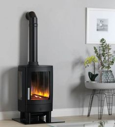 a black stove in a living room next to a table