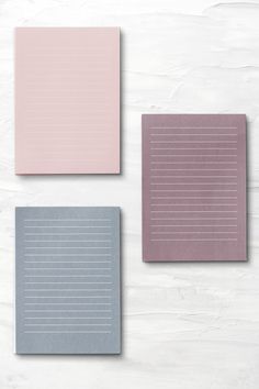 three different colors of paper on a white surface