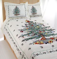 a white bed with a christmas tree on the comforter and matching pillowcases