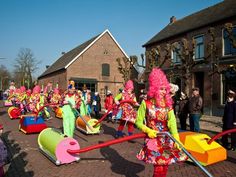 people dressed in brightly colored costumes walking down the street