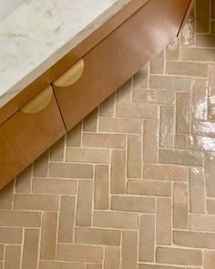 a bathroom with a marble counter top and wooden cabinets