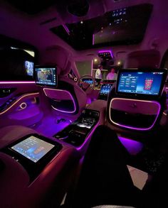 the interior of a limo with purple lighting and touch screen screens on the front seats