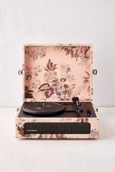 an old - fashioned record player with floral wallpaper is shown in front of a white background