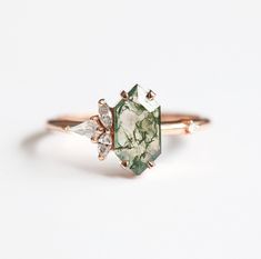 a green and white diamond ring on a white background