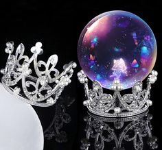 two tiaras, one with a crystal ball and the other with pearls on it