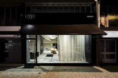 an empty store front at night with the lights on and curtains open in the window