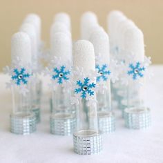 there are many small glass vases with snowflakes in them on the table