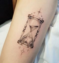 a woman's arm with an hourglass tattoo on it