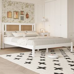 a white bed sitting on top of a wooden floor next to a wall mounted clock