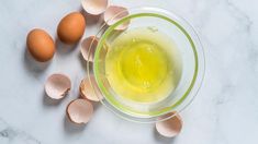 eggs and oil in a glass bowl on a marble surface