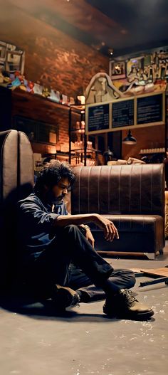 a man sitting on the floor in front of a couch