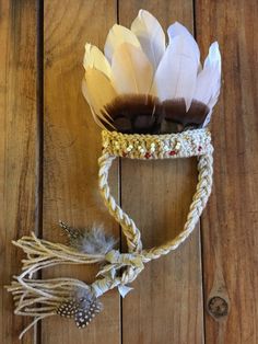 a headdress with feathers and beads on top of a wooden floor next to a string