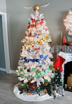 a decorated christmas tree in front of a fireplace