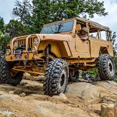 an old jeep is parked on some rocks