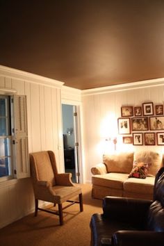 a living room filled with furniture and pictures on the wall