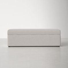 a white couch sitting on top of a floor next to a wall and a chair