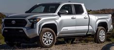 a silver truck parked on top of a hill