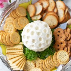 a platter with crackers, cheese ball and flowers