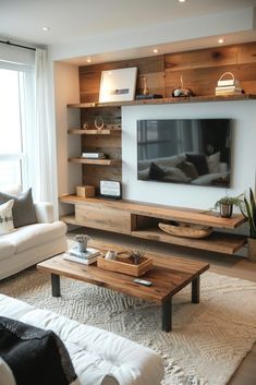 a living room filled with furniture and a flat screen tv mounted on a wall next to a window