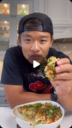 a man eating food from a bowl on top of a table