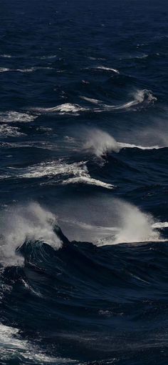 some very big waves in the ocean with dark blue water and white foam on them