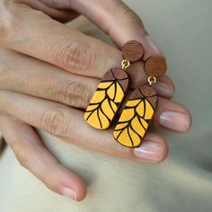 These earth-themed stud earrings made from mahogany wood, with yellow details, offer unique elegance with their chic and modern design. Handcrafted with care, each pair has a unique touch with its rustic details and charming wooden patterns. Ideal for both daily use and special occasions, they make a thoughtful Christmas gift, a memorable birthday gift, or a romantic Valentine's Day gift. Their timeless appeal also makes them an excellent choice for Teacher's Day or Mother's Day, offering a mean Unique Brown Earrings For Gift, Rectangular Yellow Earrings For Gift, Yellow Rectangular Earrings Gift, Yellow Rectangular Earrings As A Gift, Yellow Rectangular Earrings For Gifts, Artisan Yellow Earrings As Gift, Artisan Yellow Earrings For Gift, Unique Handmade Earrings, Handmade Wooden Boxes