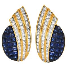 Opulent vintage late 1970s 18-karat yellow gold statement clip-on earrings Princess-Cut Diamond and Sapphire Statement Clip-On Earrings, Channel-Set Flair Design. Masterfully set within their gleaming contours are 6.40 carats of channel-set,  princess-cut natural diamonds, fashioned to flare with unbridled brilliance. Complementing this lustrous display are 4.56 carats of meticulously mystery-set square-cut natural sapphires, adding a profound depth of color to these luxurious earrings. These exquisite pieces are a celebration of refined craftsmanship and the timeless allure of fine gemstones. Secured with Clip-On closure. Measures 30mm x 15mm.  In Excellent Condition. Accompanied with official gemologist appraisal document. Luxury Fine Jewelry Clip-on Earrings, Luxury Clip-on Fine Jewelry Earrings, Luxury Designer Clip-on Jewelry, Luxury Clip-on Costume Jewelry Earrings, Luxury Hallmarked Fine Jewelry Clip-on Earrings, Luxury Yellow Gold Clip-on Earrings For Statement Jewelry, Luxury Gemstone Clip-on Earrings, Luxury Fine Jewelry Hallmarked Clip-on Earrings, Luxury Classic Clip-on Earrings With 17 Jewels