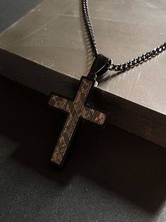 This stainless steel cross pendant features a unique textured print embossed into the steel. The black setting and chain give this necklace a sleek & modern vibe. These quality pieces will make a great addition to your men's jewelry collection or a thoughtful gift for him. Made from premium quality 316L stainless steel which means our jewelry are durable and made to last. Stainless steel is lead & nickel free, meaning they are hypoallergenic and good for those with sensitive skin!  Cross Dimensi Black Engraved Cross Pendant Necklace, Black Engraved Cross Necklace Gift, Black Engraved Crucifix Necklace, Engraved Black Cross Necklace As Gift, Gunmetal Cross Necklace In Stainless Steel, Gunmetal Cross Necklace Gift, Black Crucifix Necklace Engraved, Engraved Black Cross Necklace For Gift, Gunmetal Stainless Steel Cross Necklace