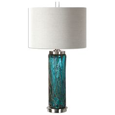 a blue glass table lamp with a white shade on the base and a silver metal frame