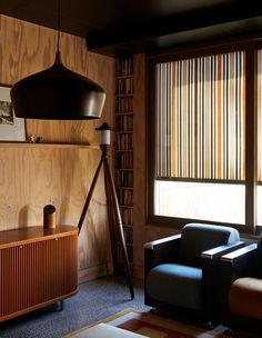 a living room filled with furniture next to a window covered in wooden slatted blinds