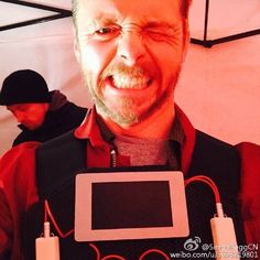 a man holding an electronic device in front of his face and smiling at the camera