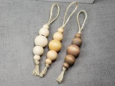 three wooden beads with tassels on a gray surface