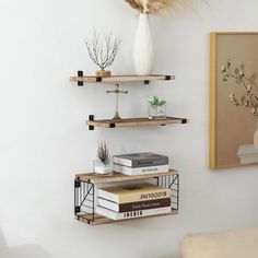 three shelves with books and vases on them in the corner of a living room