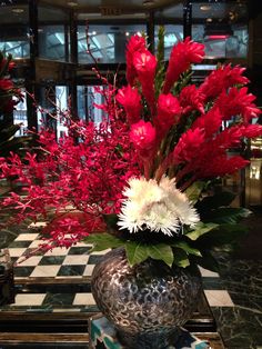 a vase filled with red and white flowers on top of a table