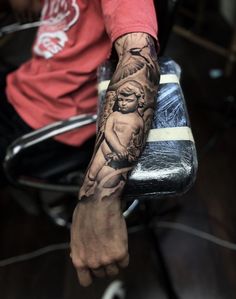 a man with a tattoo on his arm sitting in a chair