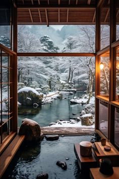 a room that has some snow on the ground and rocks in the water near it